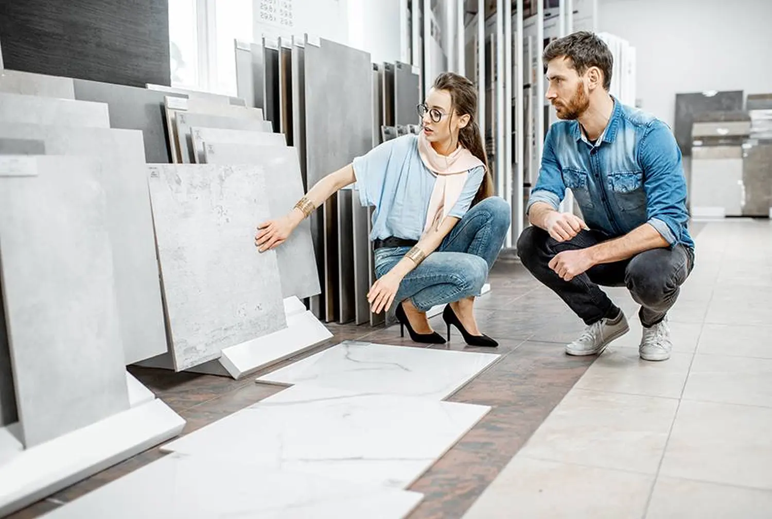 Schönes junges Paar, das in der Bauwerkstatt große Granitfliesen für die Reparatur seines Hauses auswählt